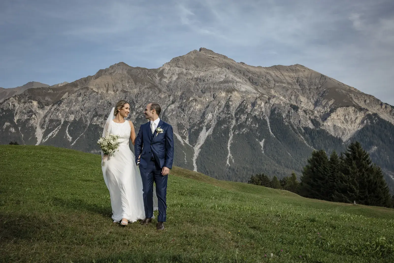 Brautpaar auf einer Alpwiese mit Bergpanorama bei einer Hochzeit auf der Lenzerheide