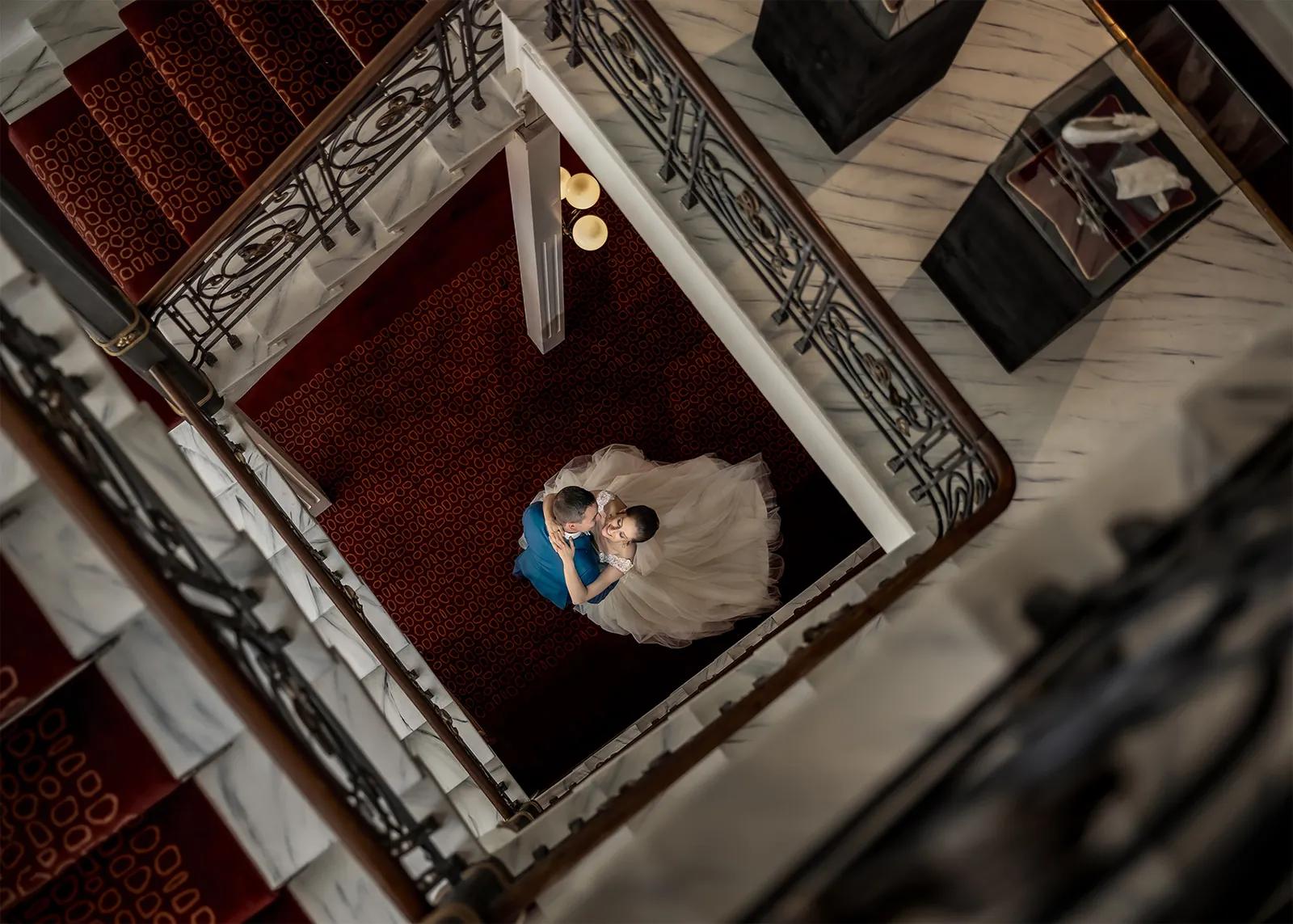 Brautpaar im historischen Treppenhaus des Schweizerhof Flims, von oben fotografiert