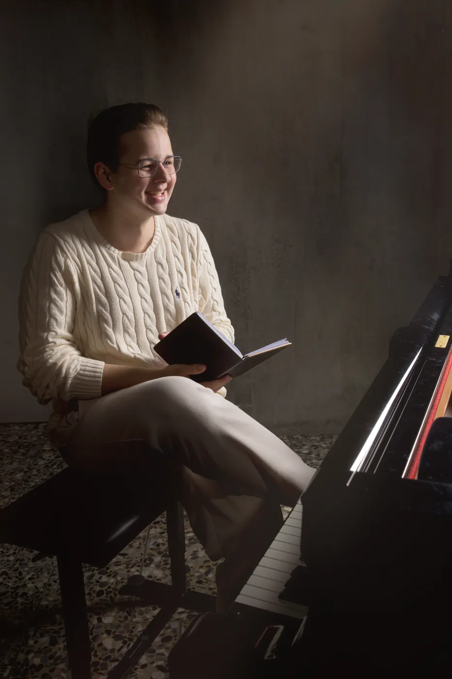 Junger Musiker am Klavier, herzliches Lachen im warmen Licht – Personal-Branding-Fotografie